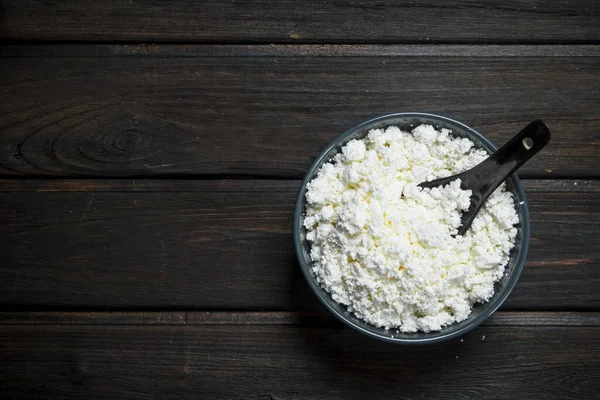 stock image Cottage cheese in bowl. On a wooden background.