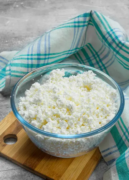 stock image Cottage cheese in bowl on napkin. On a rustic background.