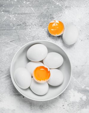 Yumurta bir kapta. Rustik bir arka plan üzerinde.