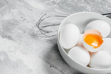 Yumurta çırpma teli ile kase. Rustik bir arka plan üzerinde