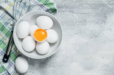 Yumurta çırpma teli ile kase. Rustik bir arka plan üzerinde