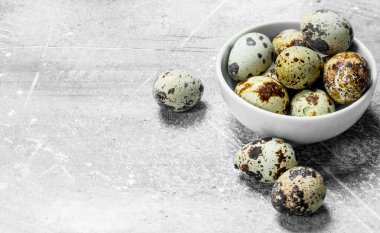 Bıldırcın yumurtası kabın içinde. Rustik bir arka plan üzerinde.