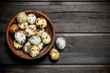 Bıldırcın yumurtası kabın içinde. Ahşap bir arka plan üzerinde.