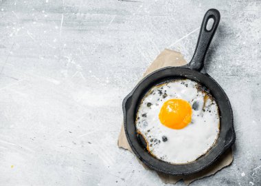 Bir tavada kızarmış yumurta. Rustik bir arka plan üzerinde.