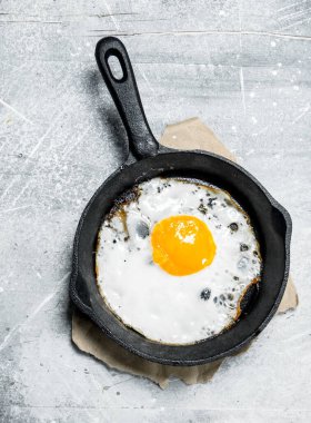 Bir tavada kızarmış yumurta. Rustik bir arka plan üzerinde.