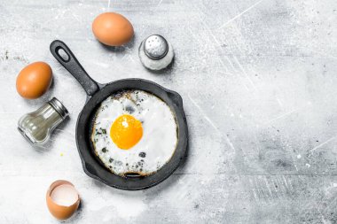 Tuz ve karabiber ile kızarmış yumurta. Rustik bir arka plan üzerinde.