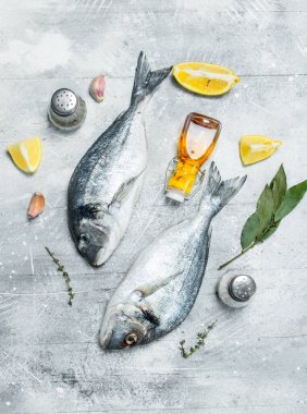 Çiğ deniz balığı limon dilimleri ve baharatlar ile. Rustik bir arka plan üzerinde.