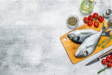 Çiğ deniz balık dorado baharat ve domates ile. Rustik bir arka plan üzerinde.