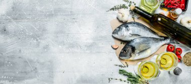 Çiğ deniz dorado beyaz şarap ile balık ve baharat. Rustik bir arka plan üzerinde.