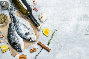 Çiğ deniz dorado beyaz şarap ile balık ve baharat. Rustik bir arka plan üzerinde.