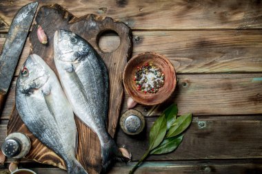 Çiğ deniz balık dorado otlar ve Aromatik baharatlar ile. Ahşap bir arka plan üzerinde.