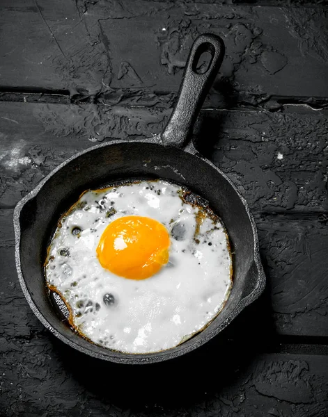 在煎锅里煎鸡蛋 在黑色乡村背景 — 图库照片
