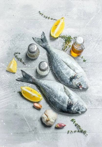 stock image Raw sea fish dorado with herbs and spices. On a rustic background.