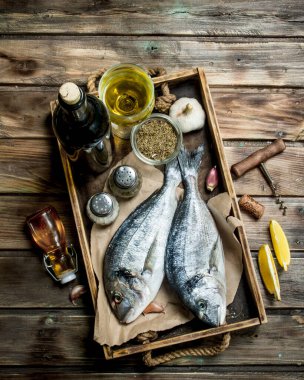 Çiğ deniz balık dorado baharat ve beyaz şarap ile. Ahşap bir arka plan üzerinde.