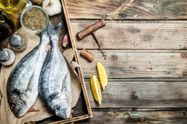 Çiğ deniz balık dorado baharat ve beyaz şarap ile. Ahşap bir arka plan üzerinde.