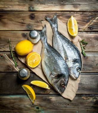 Çiğ deniz balık dorado limon, otlar ve Aromatik baharatlar ile. Ahşap bir arka plan üzerinde.