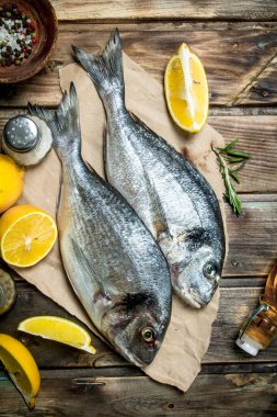 Çiğ deniz balık dorado limon, otlar ve Aromatik baharatlar ile. Ahşap bir arka plan üzerinde.