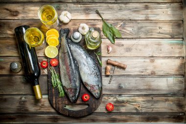 Çiğ deniz balıkla beyaz şarap ve otlar. Ahşap bir arka plan üzerinde.