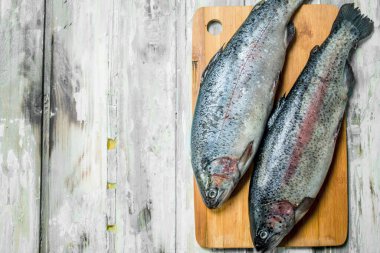 Bir kesme tahtası üzerinde çiğ balık somon. Rustik arka plan üzerinde