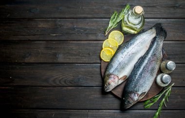 Limon dilimleri ve biberiye ile çiğ balık somon. Ahşap bir arka plan üzerinde