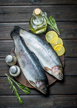 Limon dilimleri ve biberiye ile çiğ balık somon. Ahşap bir arka plan üzerinde