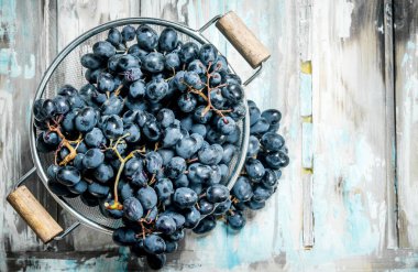 tencerede siyah üzüm. Rustik bir arka plan üzerinde.