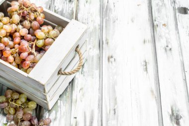 Kutuda pembe üzümler var. Rustik bir arka plan üzerinde.