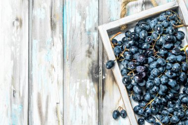 Tepside siyah üzümler. Rustik bir arka plan üzerinde.
