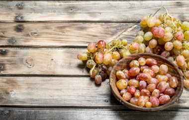 Kasede pembe üzümler. Ahşap bir arka plan üzerinde.