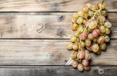 White ripe grapes. On a wooden background.