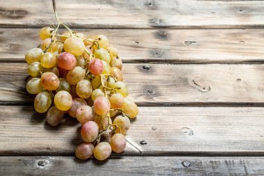 White ripe grapes. On a wooden background.