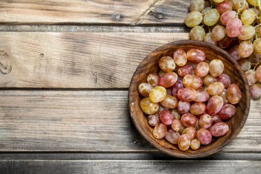 Kasede pembe üzümler. Ahşap bir arka plan üzerinde.