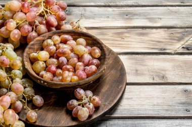 Kasede pembe üzümler. Ahşap bir arka plan üzerinde.