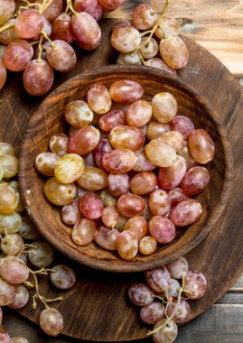 Kasede pembe üzümler. Ahşap bir arka plan üzerinde.