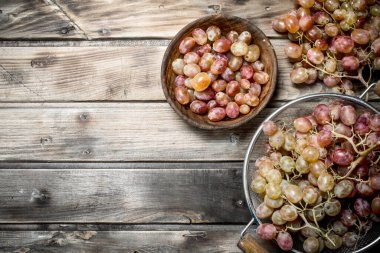 White grapes in a saucepan. On a wooden background.