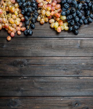 Siyah ve beyaz üzümler. Ahşap bir arka plan üzerinde.