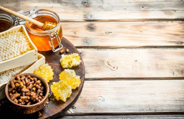 Cam Kavanoz ve gemide peteğin tatlım. Ahşap bir arka plan üzerinde.