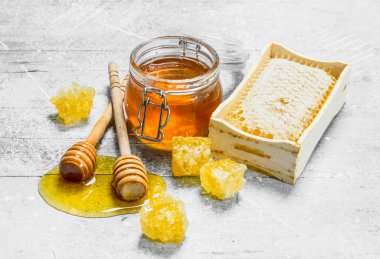 Peteğin tahta kaşıklar ile doğal bal. Rustik bir arka plan üzerinde.