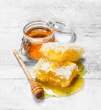 Peteğin tahta kaşıklar ile doğal bal. Rustik bir arka plan üzerinde.