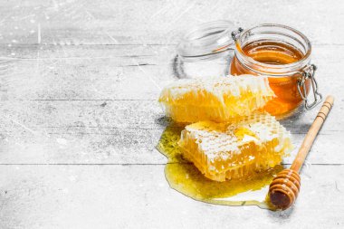 Peteğin tahta kaşıklar ile doğal bal. Rustik bir arka plan üzerinde.