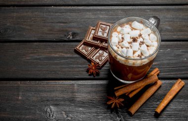 Sıcak çikolata tarçın ve marshmallow ile. Ahşap bir arka plan üzerinde.