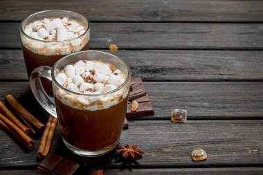 Sıcak çikolata tarçın ve marshmallow ile. Ahşap bir arka plan üzerinde.