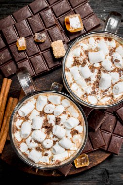 marshmallow ile bir bardak ot çikolata. Ahşap bir arka plan üzerinde.