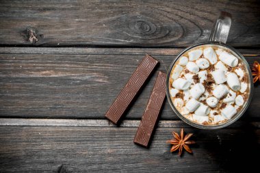 ot çikolata marshmallow ile bir fincan. Ahşap bir arka plan üzerinde.