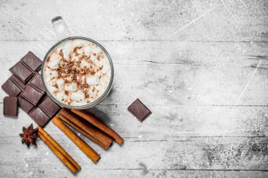 Sıcak çikolata şekerleme ve tarçın ile. Rustik bir arka plan üzerinde.