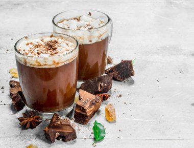 Sıcak çikolata bitter çikolata ve şekerleme parçaları ile. Rustik bir arka plan üzerinde.