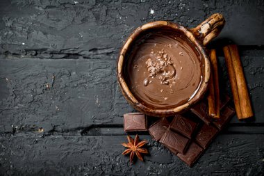Sıcak çikolata tarçın ile sopa. Rustik siyah arka plan üzerine.