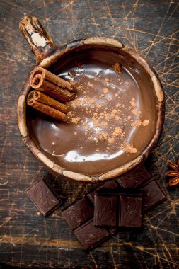 Sıcak çikolata tarçın ile sopa. Ahşap bir arka plan üzerinde.