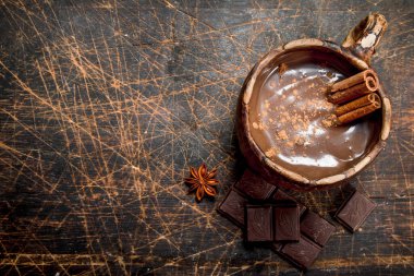 Sıcak çikolata tarçın ile sopa. Ahşap bir arka plan üzerinde.