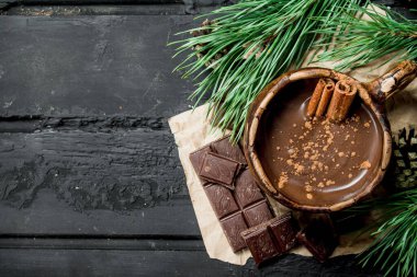 Sıcak çikolata tarçın ile sopa. Rustik siyah arka plan üzerine.